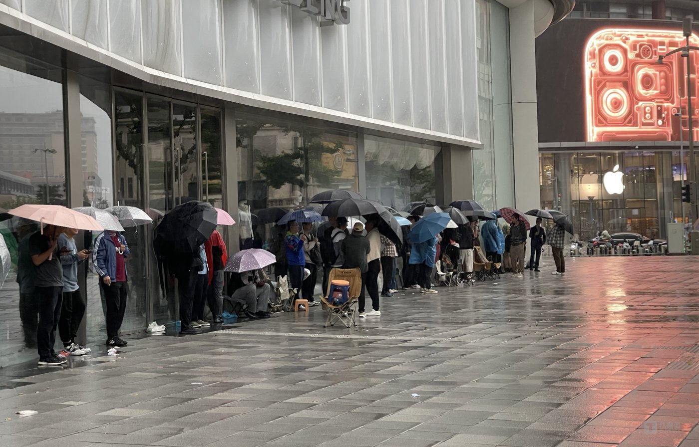 华为门店熬夜排队的人与马路另一半的苹果店，钛媒体APP拍摄